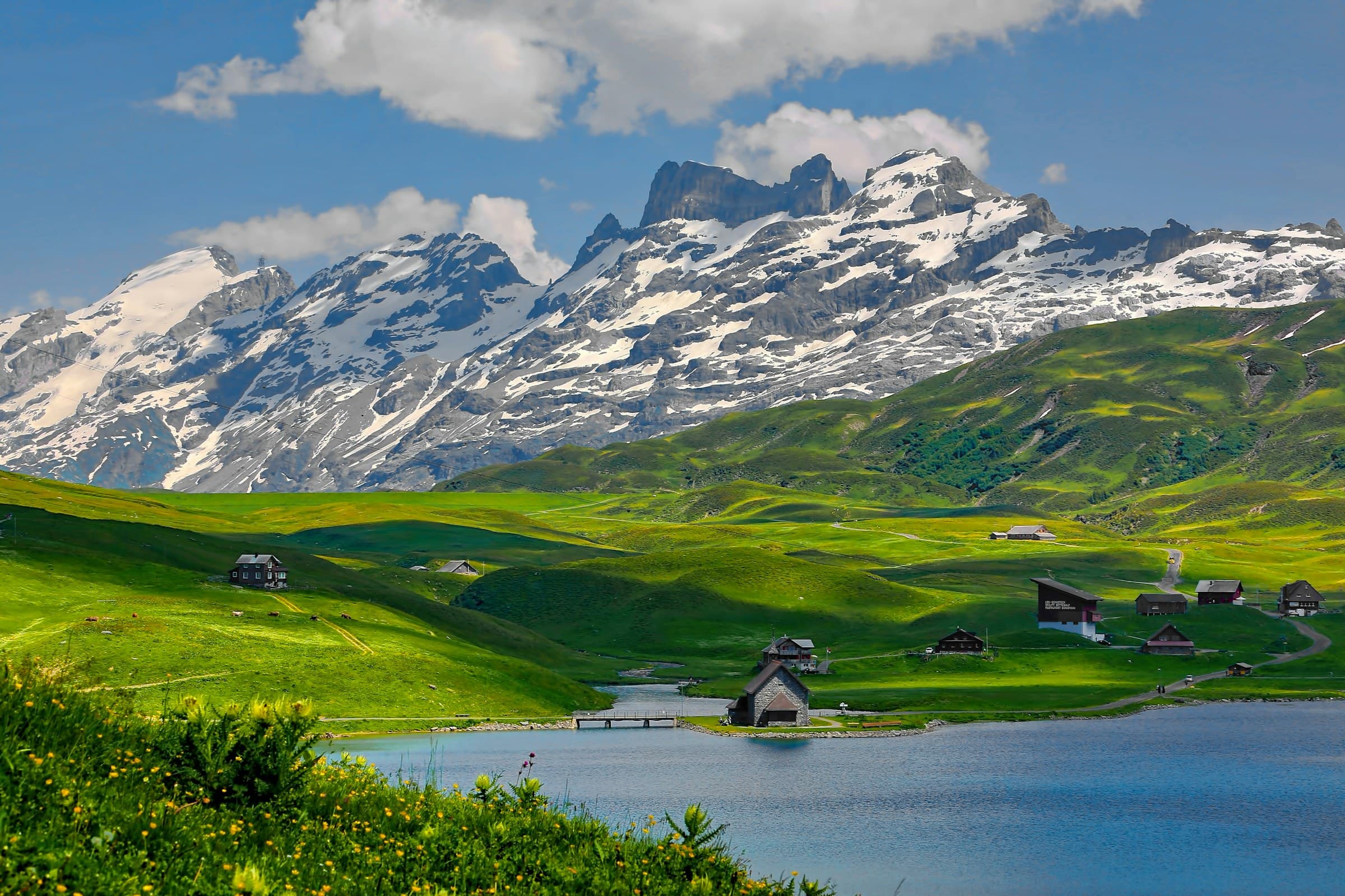 An alpine lake and scattered chalets below the Swiss peaks